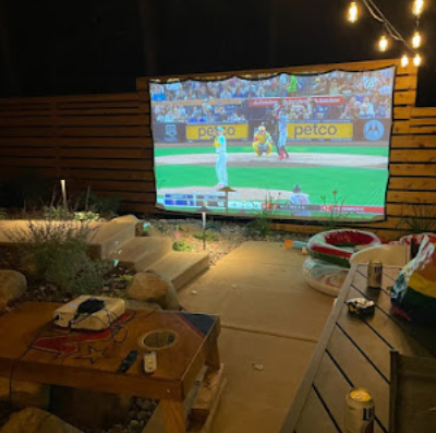 Outdoor patio home theater with projector screen for game night